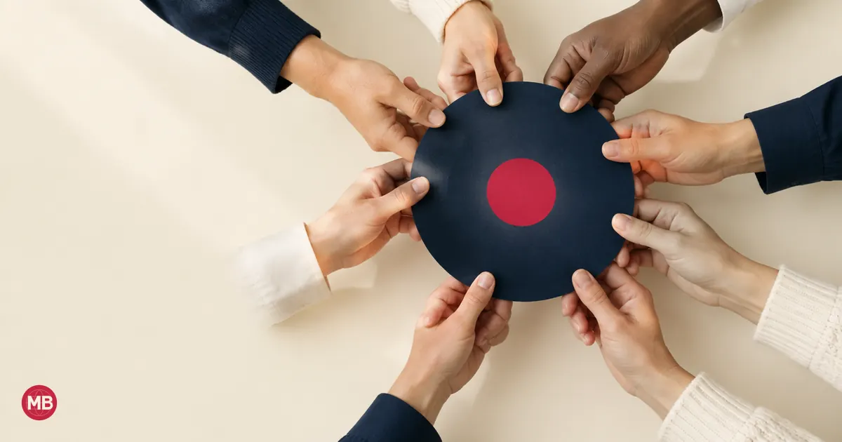 Many hands holding the rim of a navy paper disc with a red dot at its centre