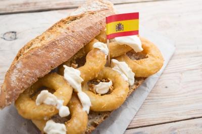 A sandwich with onion rings and a small flag